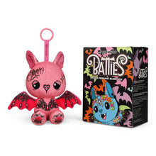 Load image into Gallery viewer, Pink bat-shaped plush toy with decorative elements next to its packaging on a white background